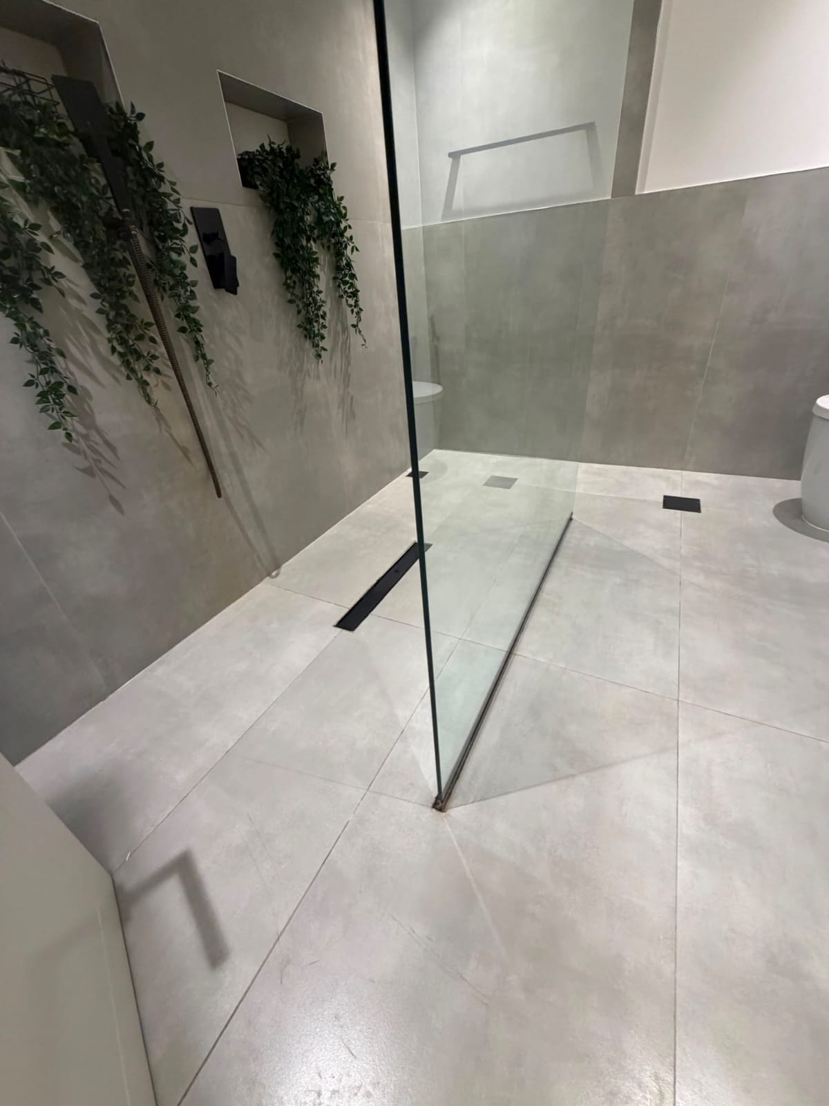 Modern bathroom with large-format tiles and glass shower partition
