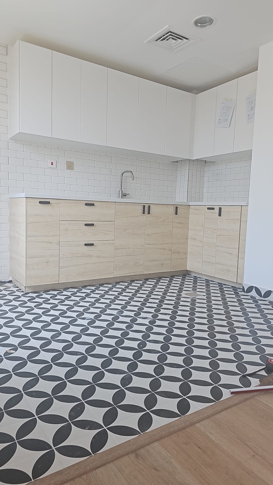 Fitted kitchen with cabinetry, backsplash tiles and patterned floor