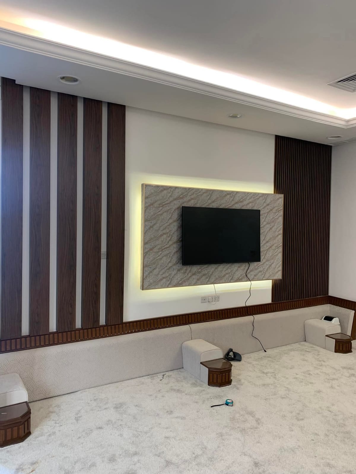 Living-room TV wall with wood panelling and marble finish